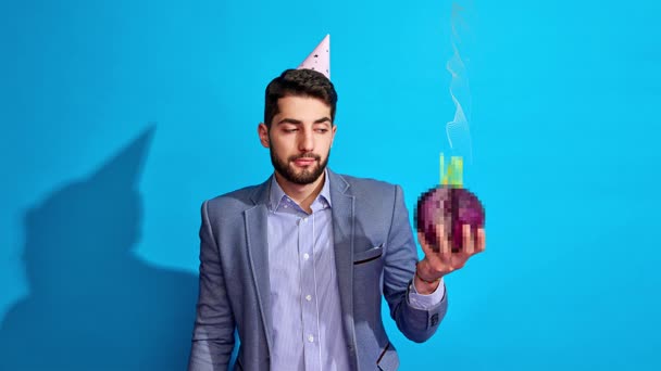 Serious businessman holding cabbage with single candle on blue background. Concept of corporate celebration campaign birthday marketing visual event promotion and humorous business advertising. Serious businessman holding cabbage with single candle on blue background. Concept of corporate celebration campaign birthday marketing visual event promotion and humorous business advertising.