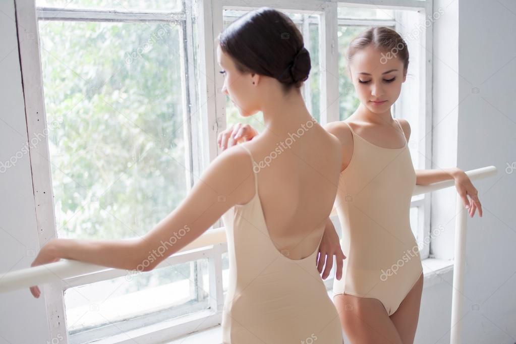 The two classic ballet dancers posing at barre