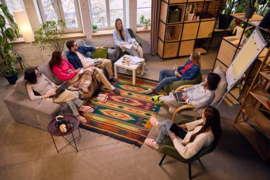 Girişimci ekibin tavan arası çalışma alanında beyin fırtınası yapmasının genel görünümü. İşbirlikçi strateji oturumu, yaratıcı ajans takım çalışması ve modern kurumsal kültür kavramı.