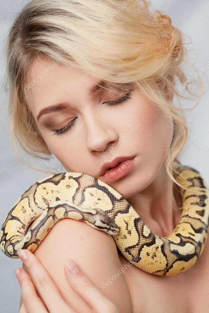 Beautiful girl holding a python, which wraps around her body Stock ...
