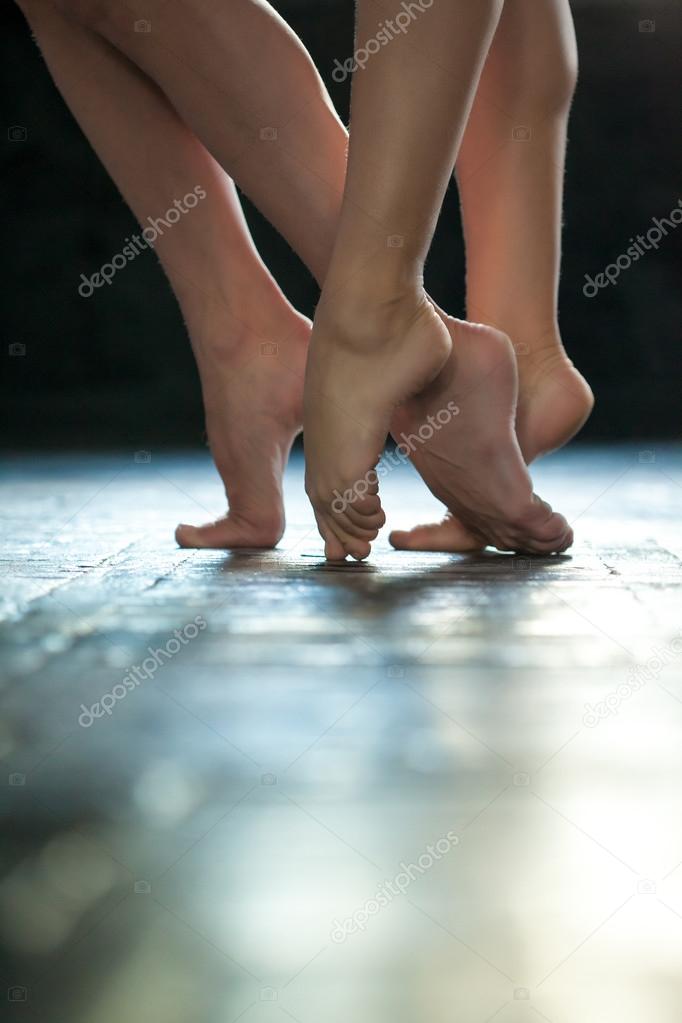 Close-up ballerinas legs on the wooden floor