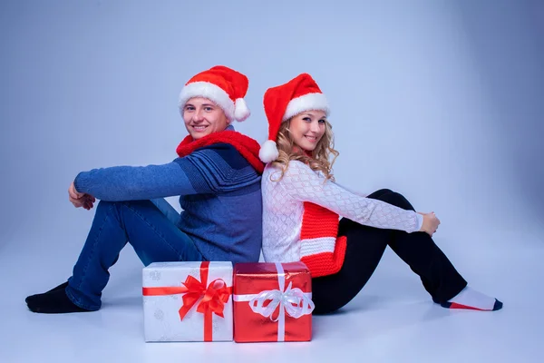 Charmant couple de Noël assis avec des cadeaux — Photo