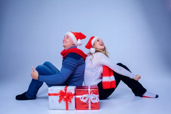 Preciosa pareja de Navidad sentada con regalos —  Fotos de Stock