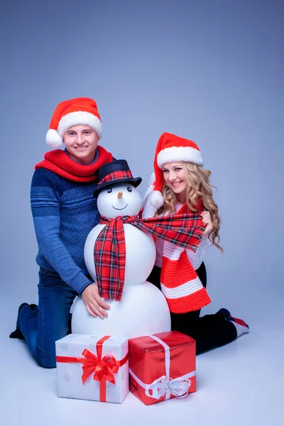 Preciosa pareja de Navidad sentada con regalos — Foto de Stock