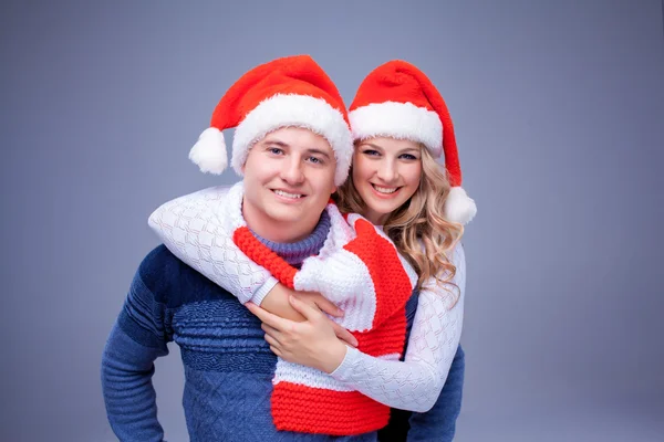 Piękna para Bożego Narodzenia w Santa Claus kapelusze — Zdjęcie stockowe
