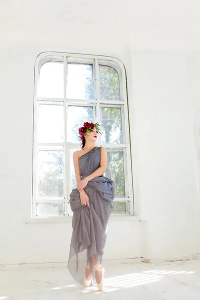 De prachtige ballerina dansen in lang grijze jurk — Stockfoto