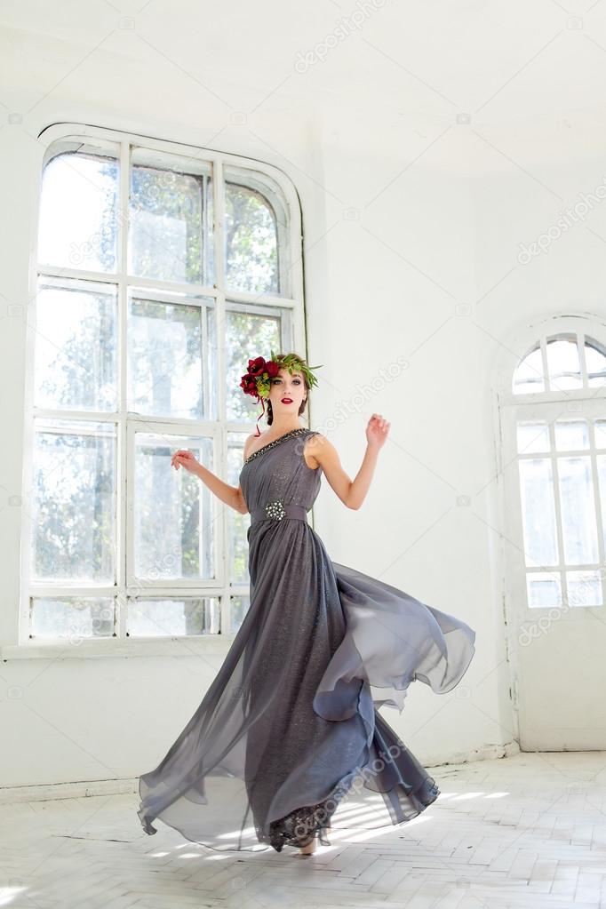 The beautiful ballerina dancing in long gray dress