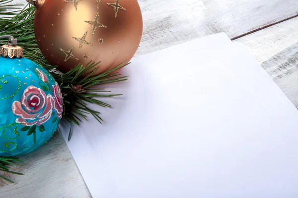 La hoja de papel sobre mesa de madera con decoraciones navideñas —  Fotos de Stock