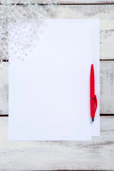 A folha de papel em branco na mesa de madeira com uma caneta — Fotografia de Stock