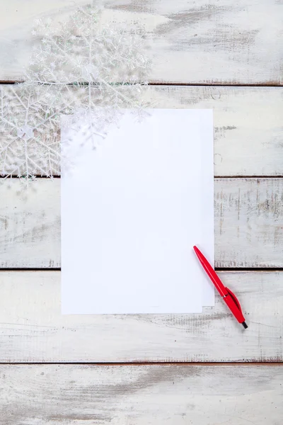 A folha de papel em branco na mesa de madeira com uma caneta — Fotografia de Stock