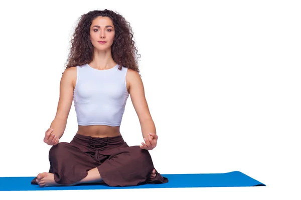 Studio shot of a young fit woman doing yoga exercises. — Stock Photo, Image