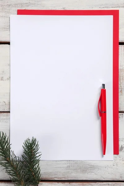 A folha de papel em branco na mesa de madeira com uma caneta — Fotografia de Stock