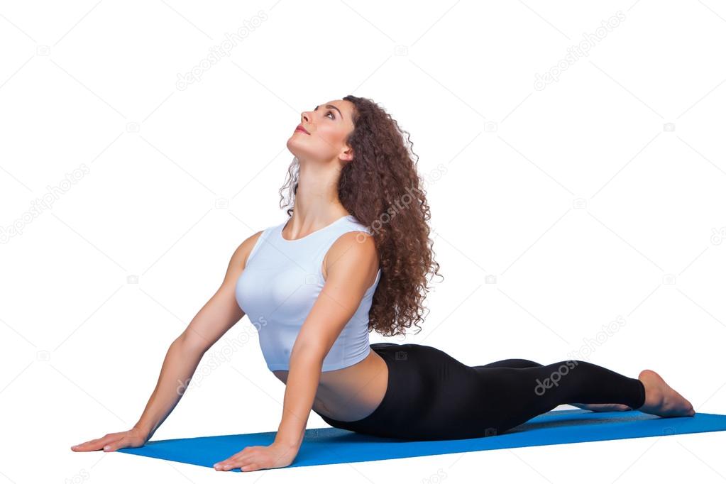 Studio shot of a young fit woman doing yoga exercises.