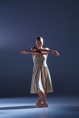Gri arka plan üzerinde dans bej elbise genç güzel dansçı