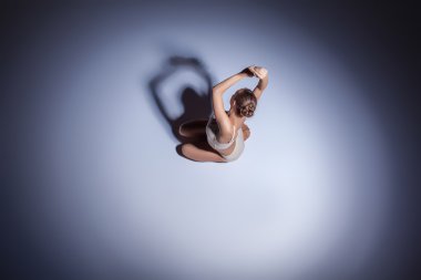 Genç güzel dansçı da bej mayo leylak arka planda dans