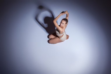 Genç güzel dansçı da bej mayo leylak arka planda dans