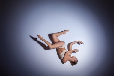 Genç güzel dansçı da bej mayo leylak arka planda dans