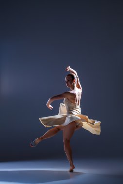 Gri arka plan üzerinde dans bej elbise genç güzel dansçı