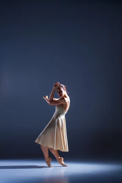 Jovem dançarina bonita em vestido bege dançando em fundo cinza — Fotografia de Stock