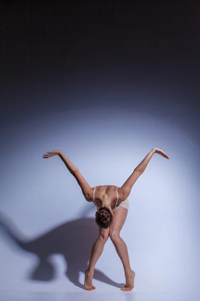 Jovem dançarina bonita em roupa de banho bege dançando em fundo lilás — Fotografia de Stock