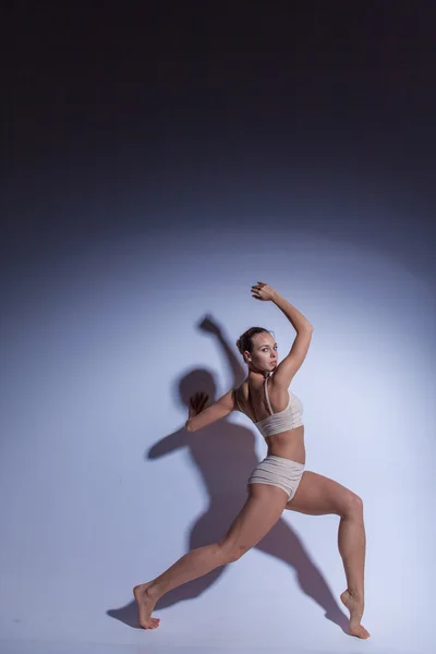 Genç güzel dansçı da bej mayo leylak arka planda dans — Stok fotoğraf