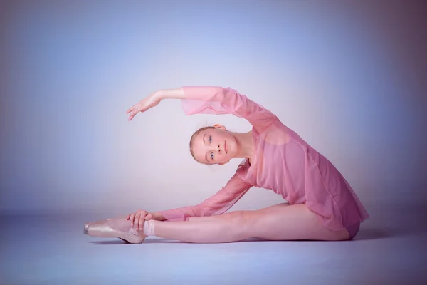 Молодая балерина позирует на полу — стоковое фото