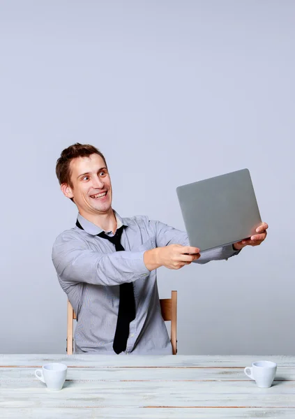 Glücklicher Mann, der im Büro am Laptop arbeitet — Stockfoto