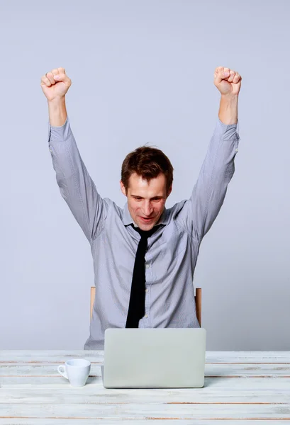 Glücklicher Mann, der im Büro am Laptop arbeitet — Stockfoto