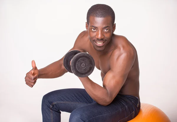 Chico fuerte y musculoso con mancuerna sobre fondo blanco — Foto de Stock