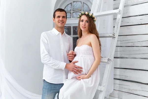 Веселая молодая пара, одетая в белое, стоящая дома — стоковое фото