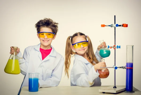 Two cute children at chemistry lesson making experiments — Stock Photo, Image