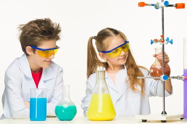 Duas crianças bonitas na aula de química fazendo experimentos — Fotografia de Stock