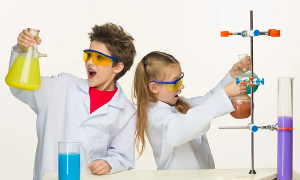 Два милых ребенка на уроке химии проводят эксперименты — стоковое фото
