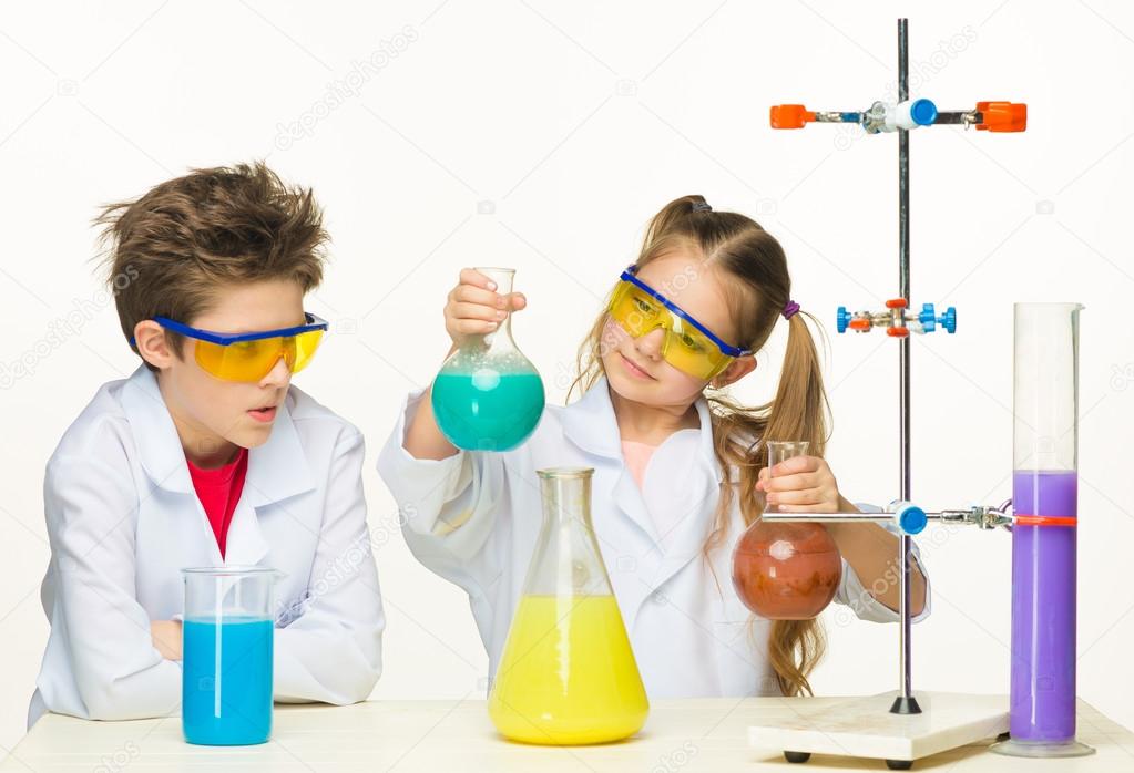 Two cute children at chemistry lesson making experiments