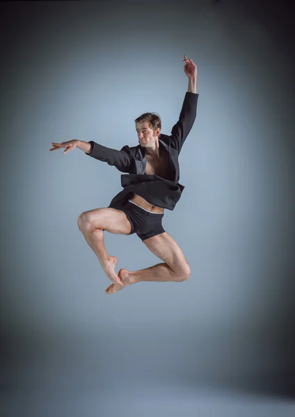 회색 배경에 점프 젊은 매력적인 현대 발레 댄서 — 스톡 사진
