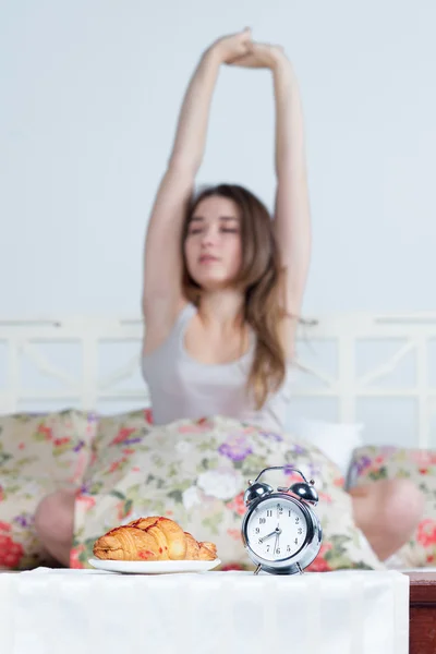 Το νεαρό κορίτσι στο κρεβάτι με υπηρεσία ρολόι — Φωτογραφία Αρχείου