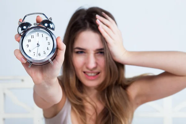 La joven en la cama con servicio de reloj — Foto de Stock