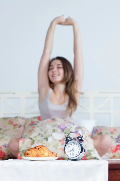 La joven en la cama con servicio de reloj —  Fotos de Stock