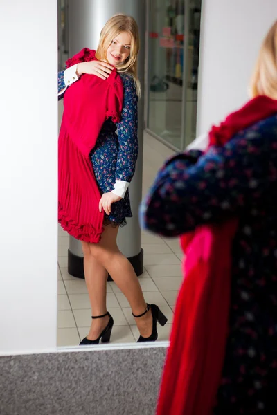 Kvinnan försöker röd klänning shopping för kläder. — Stockfoto