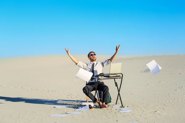 Hombre de negocios con ordenador portátil en un desierto — Foto de Stock