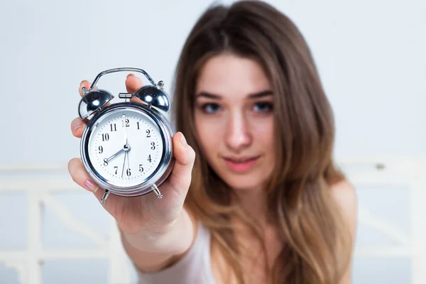 La joven en la cama con servicio de reloj — Foto de Stock