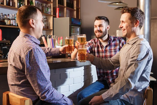Happy vrienden drinken bier aan balie in pub — Stockfoto