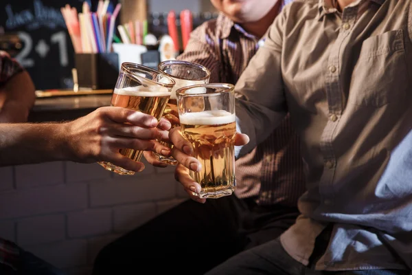 Amici felici che bevono birra al bancone nel pub — Foto Stock