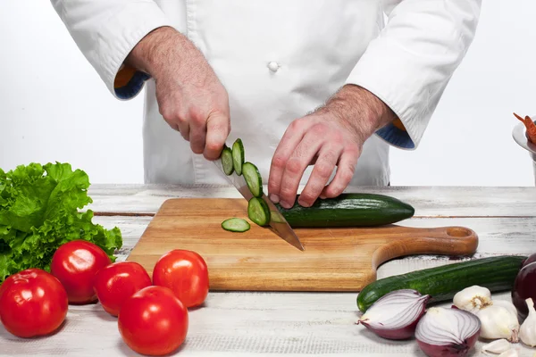 Chef taglia un cetriolo verde nella sua cucina — Foto Stock