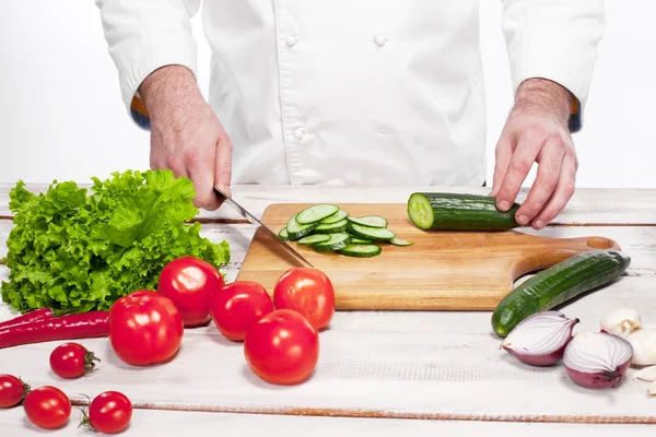 Chef taglia un cetriolo verde nella sua cucina — Foto Stock