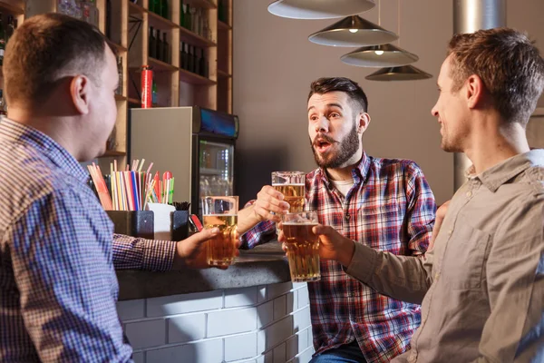快乐的朋友在酒吧柜台喝啤酒 — 图库照片