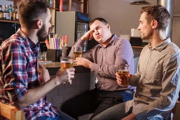 Os amigos bebem cerveja no balcão no pub — Fotografia de Stock