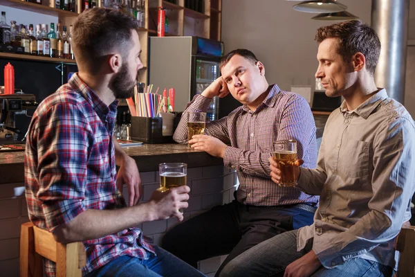 Os amigos bebem cerveja no balcão no pub — Fotografia de Stock
