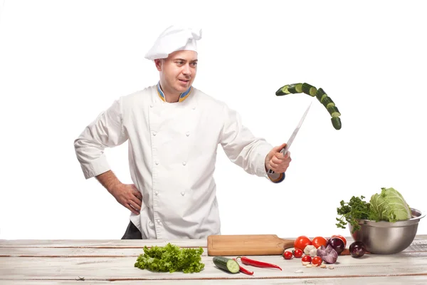 Chef cutting a green cucumber in his kitchen — Stock Photo, Image