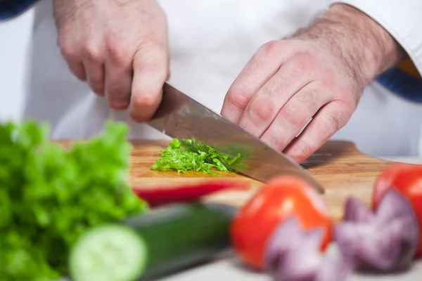 Chef tagliare una lattuga verde la sua cucina — Foto Stock
